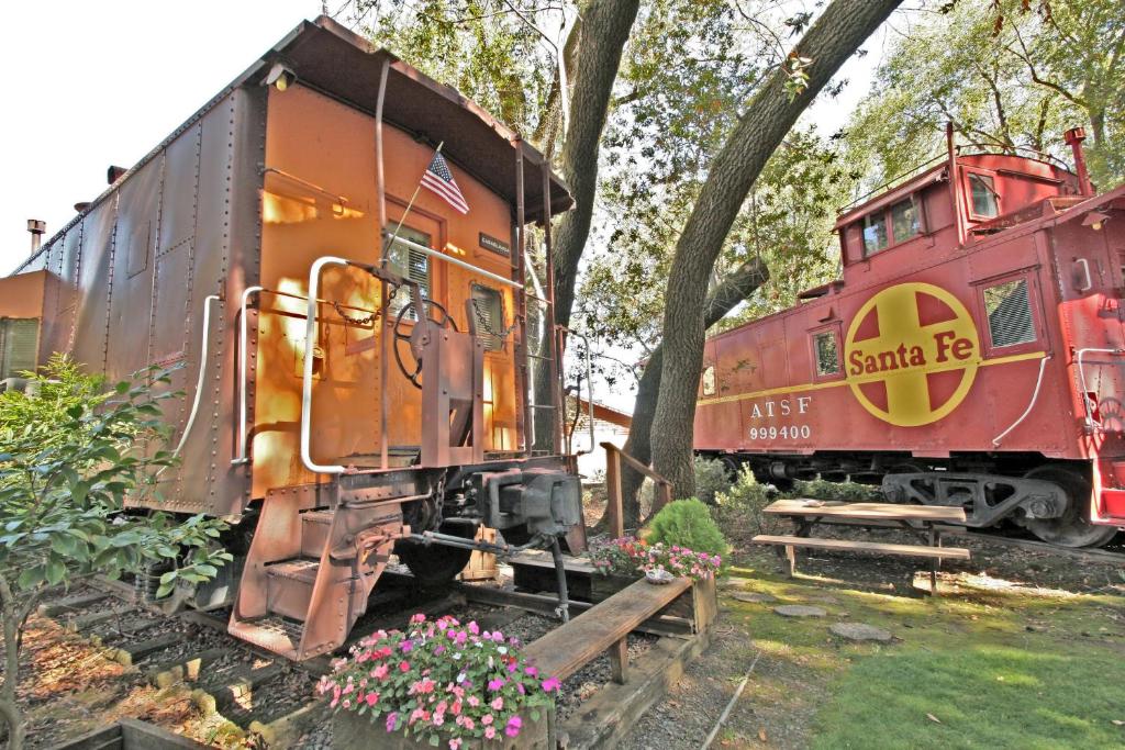 an orange train sitting on tracks next to a tree at Featherbed Railroad in Upper Lake