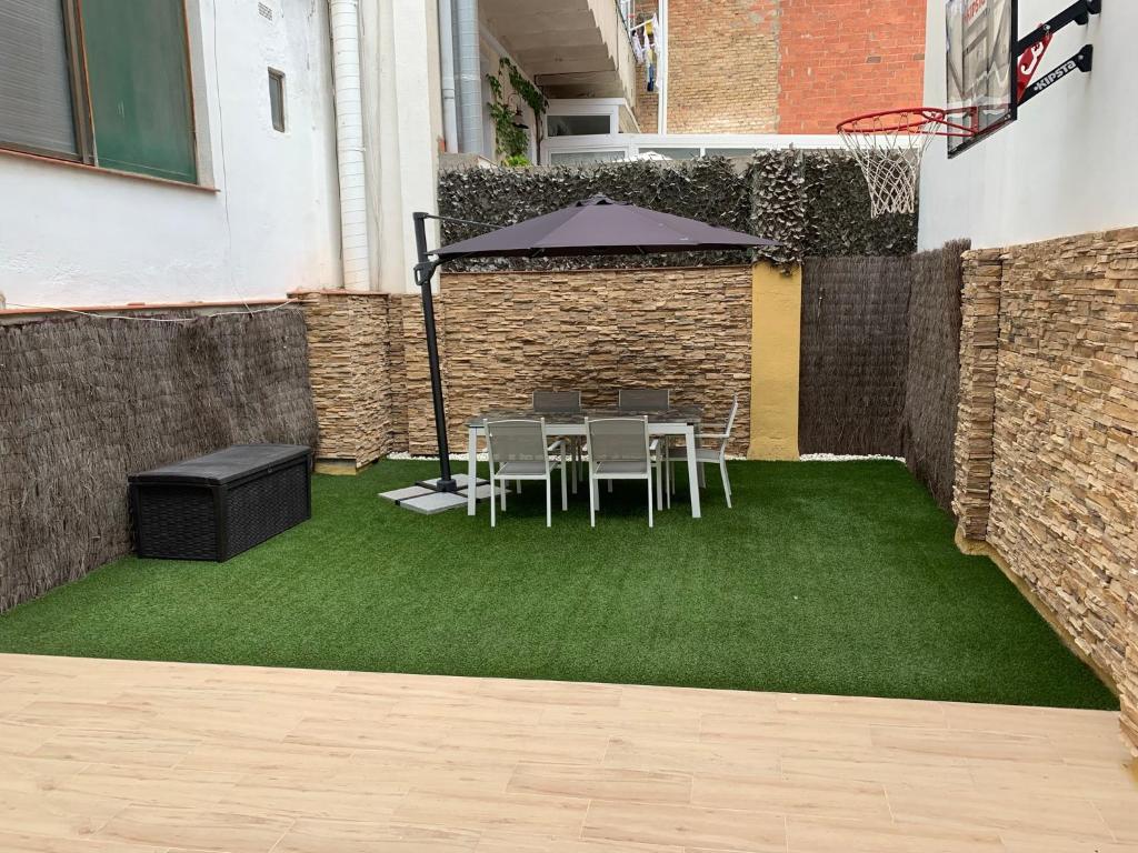 タラゴナにあるLuxury Apartment Mercat Centralの芝生の上にテーブルと椅子、傘