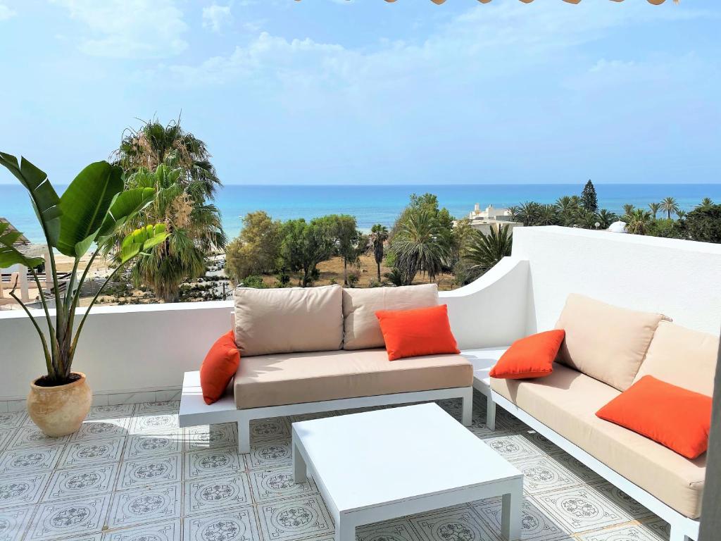a patio with two couches and a view of the ocean at Roof Top Pied dans l'Eau Panoramic View, 80 meters from Seaside in Hammamet