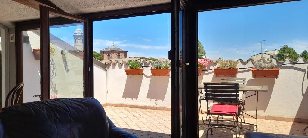 Camera con vista su un balcone con tavolo e sedie. di Corte Cavour. Una mansarda nel cuore della città a Ravenna