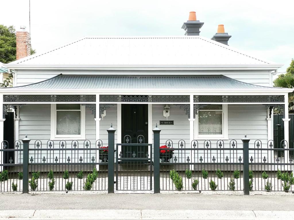 una casa blanca con una valla delante en Saint Brides - Superior Boutique Accomodation - STEPS TO PAKINGTON STREET, en Geelong