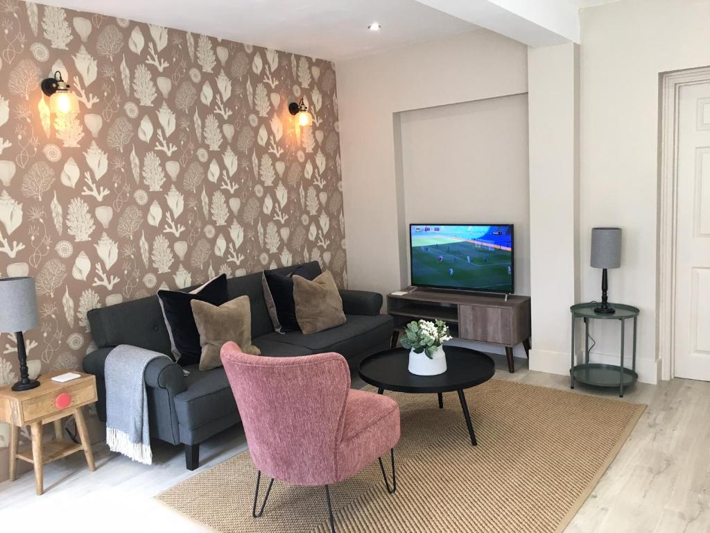 a living room with a couch and a tv at Shoemakers Cottage in Ramsgate