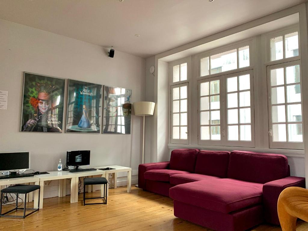 a living room with a red couch and a desk at Rivoli Cinema Hostel in Porto