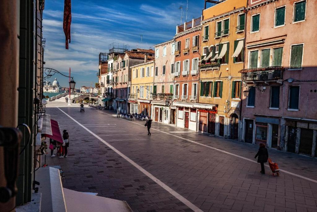 un gruppo di persone che camminano per una strada con edifici di Appartamenti Superior in Via Garibaldi by Bricola Apartments a Venezia