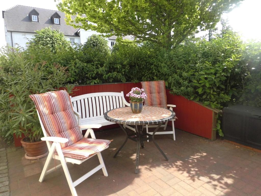 a patio with a table and two chairs and a bench at Möwe in Steffenshagen