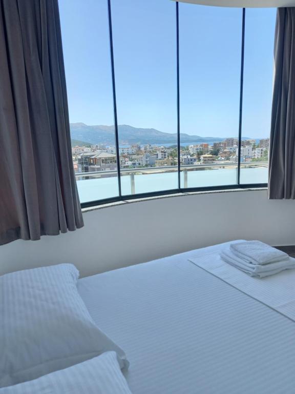 a bed in a room with a large window at Vila Olserd Shehu in Ksamil