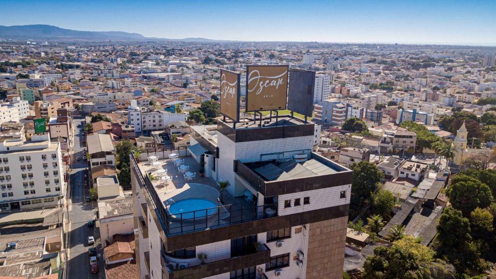 a building with a sign on top of it in a city at HOTEL OSCAR GOLD in Montes Claros