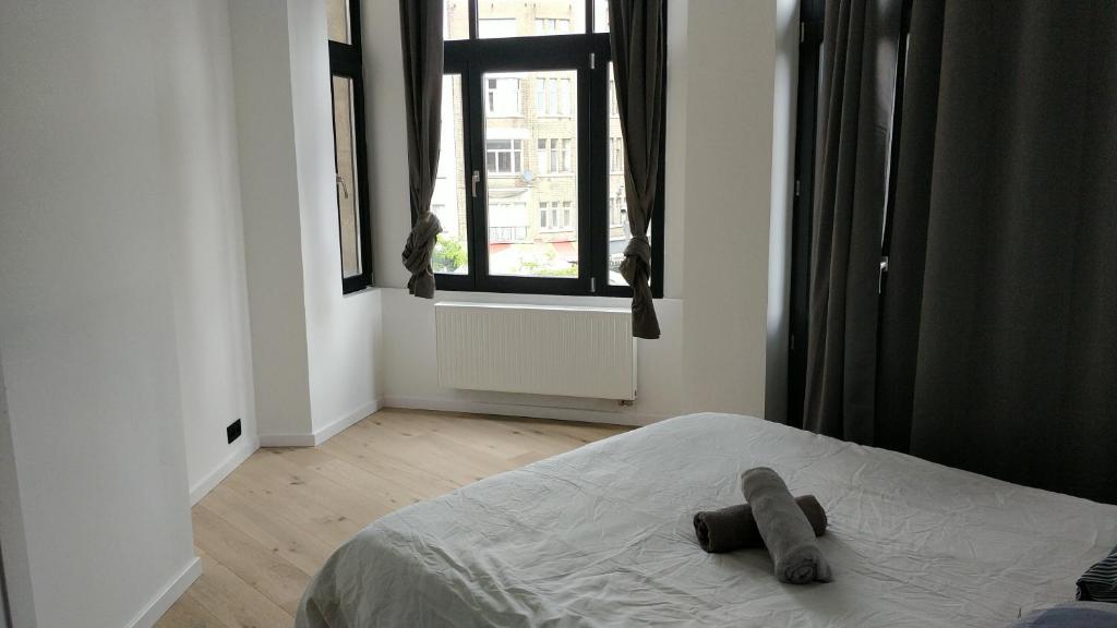 een teddybeer op een bed in een slaapkamer bij Brussels flat in Brussel