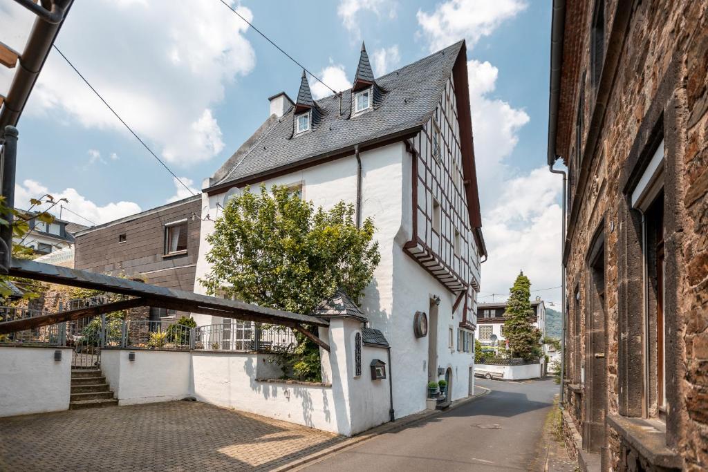 um edifício branco com um telhado preto numa rua em Zur Alten Weinkelter - bezauberndes Fachwerkhaus aus der Spätgotik von 1451 - Top Lage für Aktivitäten - Fahrradkeller em Ellenz-Poltersdorf