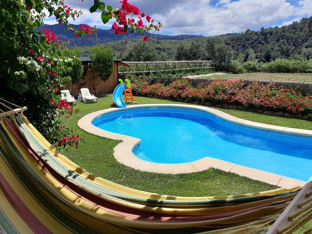 a swimming pool in a yard with a hammock around it at La Caseta de Mollet in Benifallet