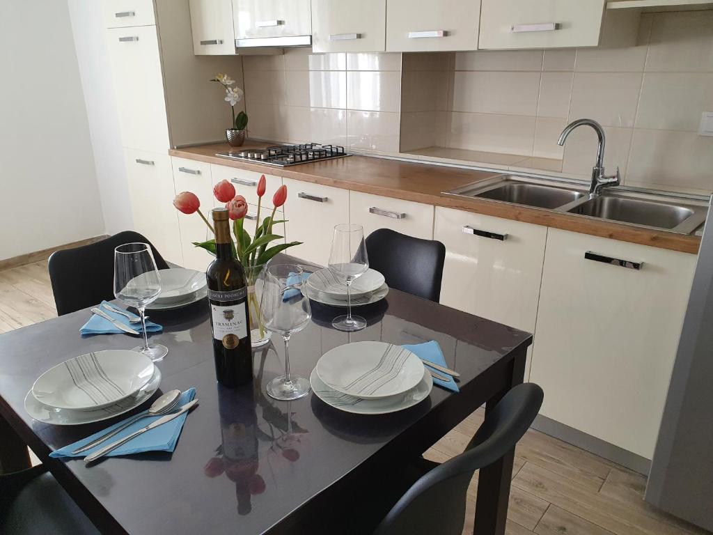 a kitchen with a table with plates and wine glasses at Apartaments Ukić in Prvić Šepurine