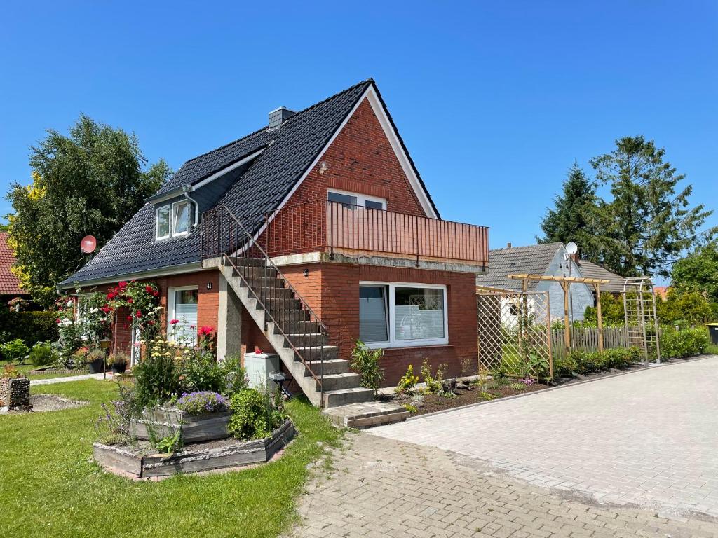 a red brick house with a staircase in the yard at FeWo Tant Jantje in Moordorf in Südbrookmerland