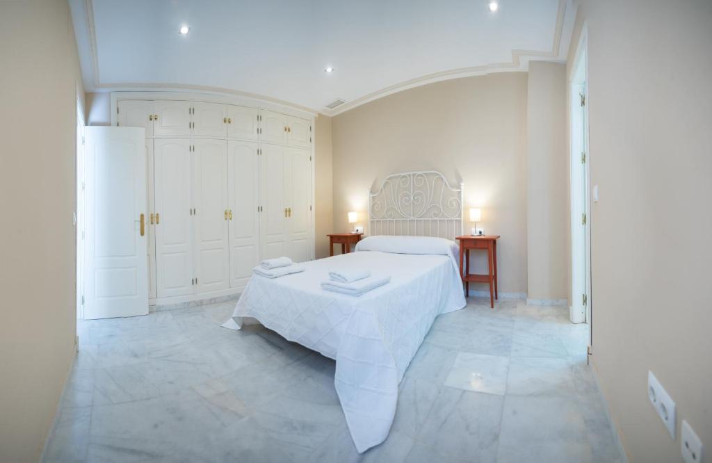 1 dormitorio blanco con 1 cama y 2 mesitas de noche en Caminito del Falla B Ha Apartment, en Cádiz