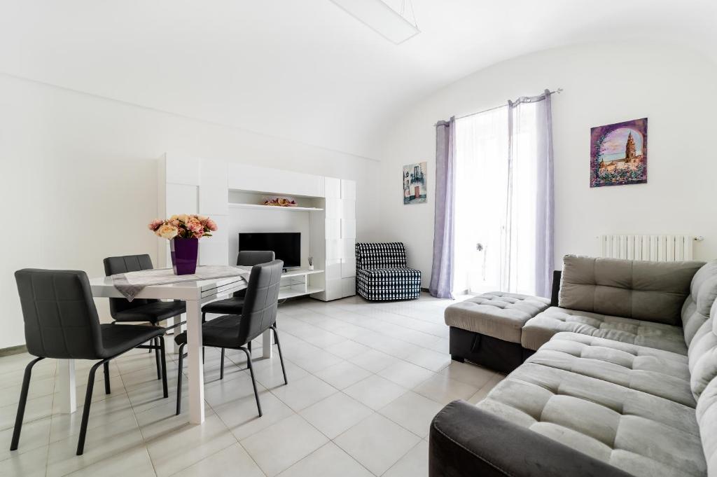 una sala de estar con una mesa y un sofá en Palazzo Fiordaliso - Puglia Mia Apartments, en Monopoli