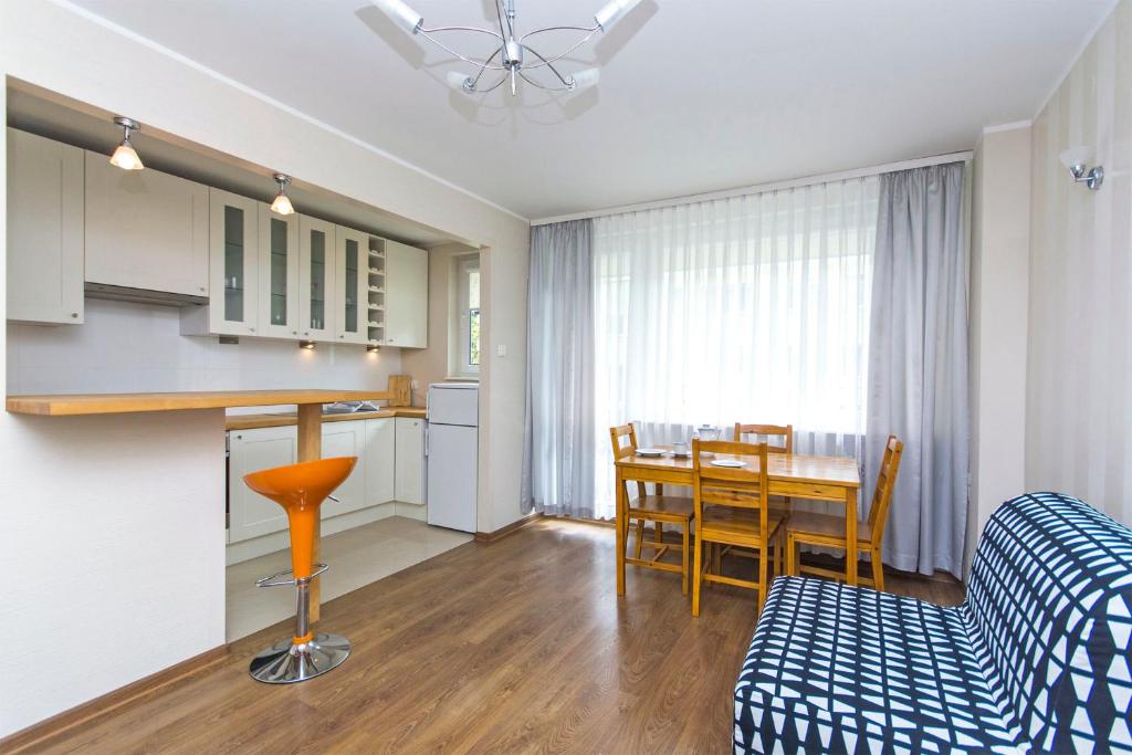 a kitchen and living room with a table and a couch at Apartament Nadmorski Wyspa Sobieszewska in Gdańsk