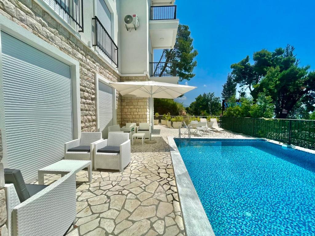 a house with a swimming pool with chairs and a building at Seaside Apartments Sword in Bar