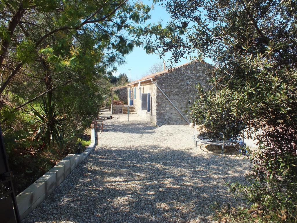 a stone house with a pathway leading to a building at Sur la Bonnefooi in Prades-sur-Vernazobre