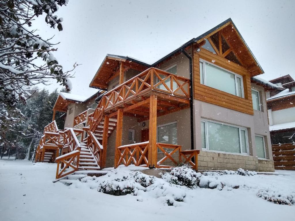 a house with snow on the ground in front of it at Andalue in San Carlos de Bariloche