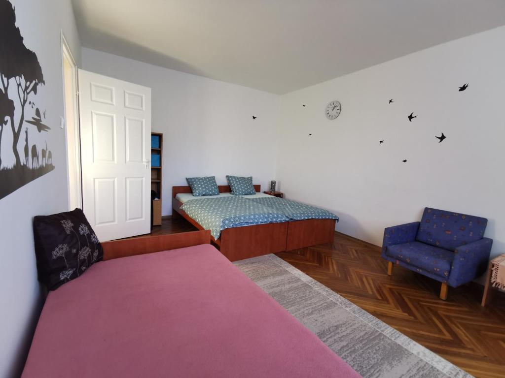 een slaapkamer met een bed, een bank en een stoel bij Arena Apartment in Szombathely