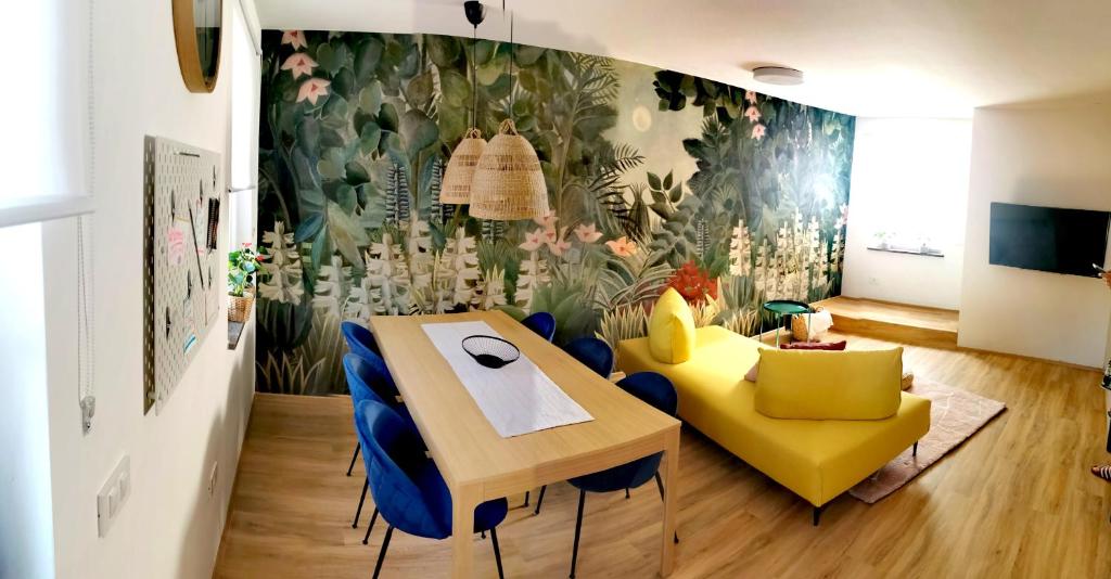a dining room with a table and blue chairs at Rainbow apartment, Koper in Koper