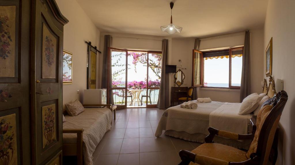 um quarto de hotel com duas camas e uma varanda em Villa Sarina em Acciaroli