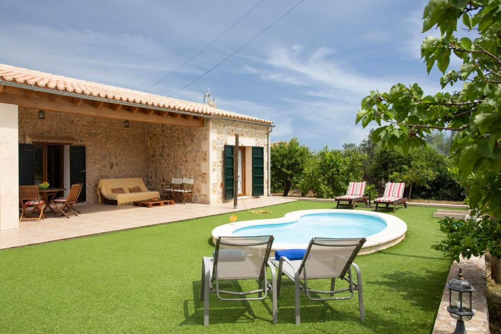 une cour avec une piscine, des chaises et une maison dans l'établissement Finca Pou Monjo, à Caimari