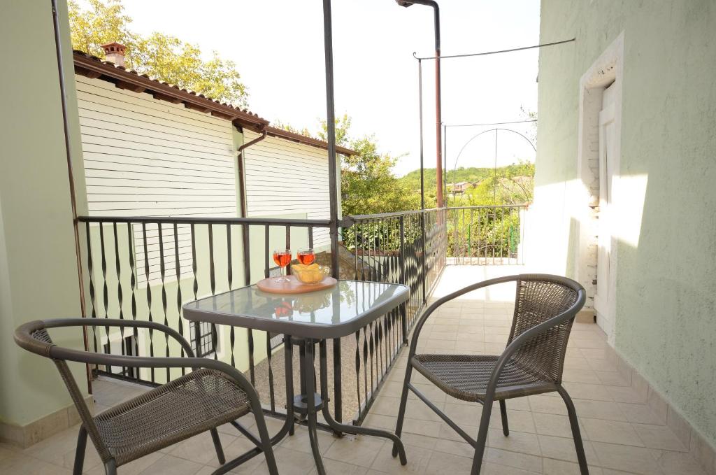普埃尼亞戈的住宿－Corte Vezzola Trilocale Tommaso，阳台配有一张桌子和两把椅子