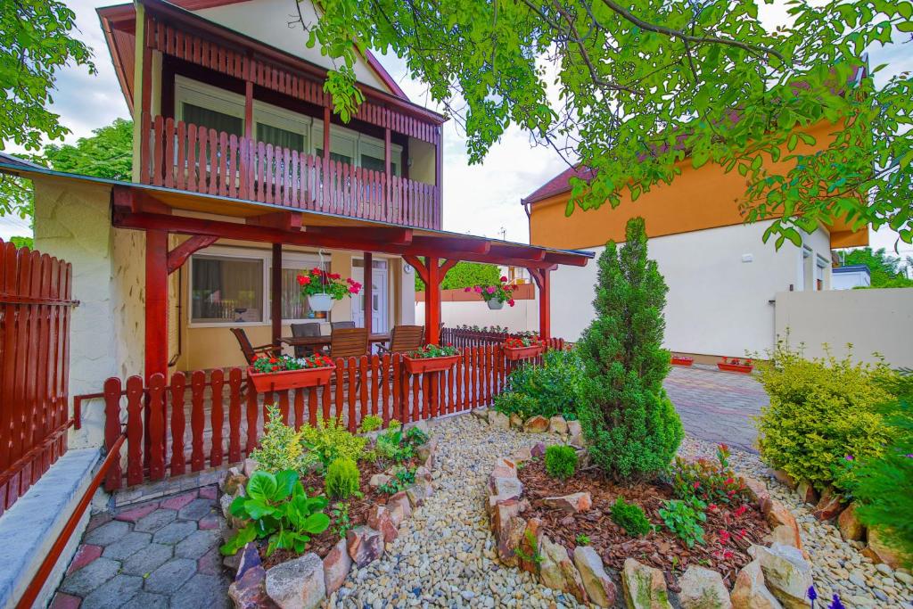 dom z czerwonym płotem i patio w obiekcie Mária Apartman w Hajduszoboszlo