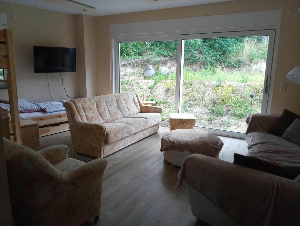 a living room with a couch and chairs and a window at Therapiescheune Egsdorf - Monteurwohnungen in Egsdorf