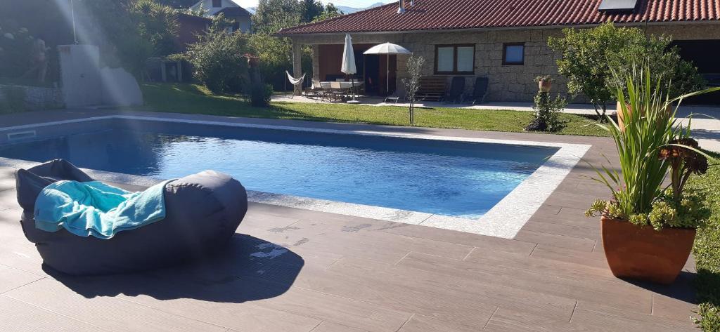 a pool with a bean bag chair next to a house at Cottage, Casa do Laranjal - Near Gerês in Geres