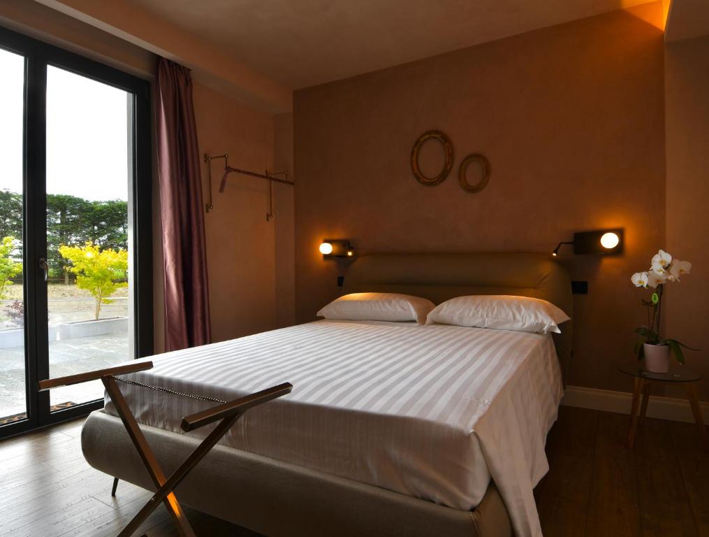 a bedroom with a large bed and a large window at B&B Bricco della Guardia in Briaglia
