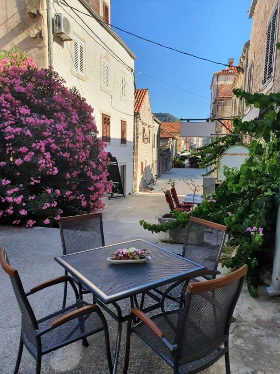 Apartman Kalinić في ستون: طاولة وكراسي عليها صحن ورد