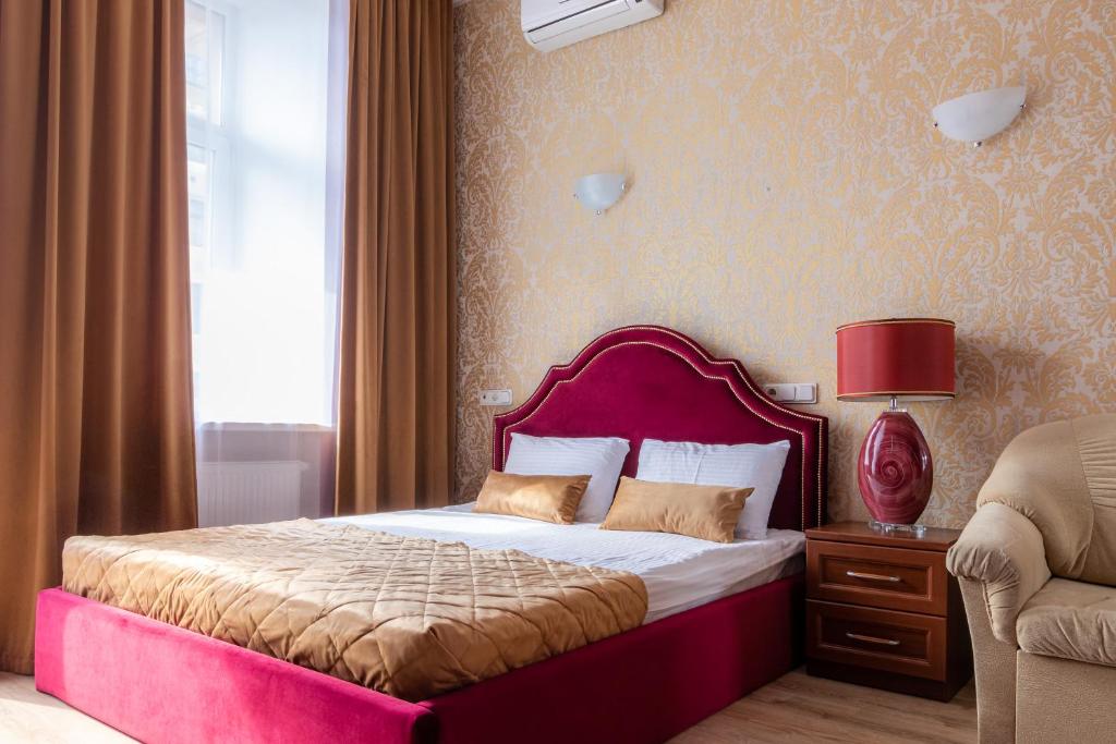 a bedroom with a large bed with a pink headboard at Dom Knyazya in Saint Petersburg