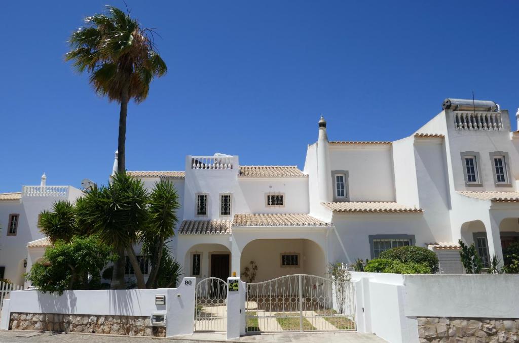 a large white house with a palm tree at Villa a Sul in Albufeira