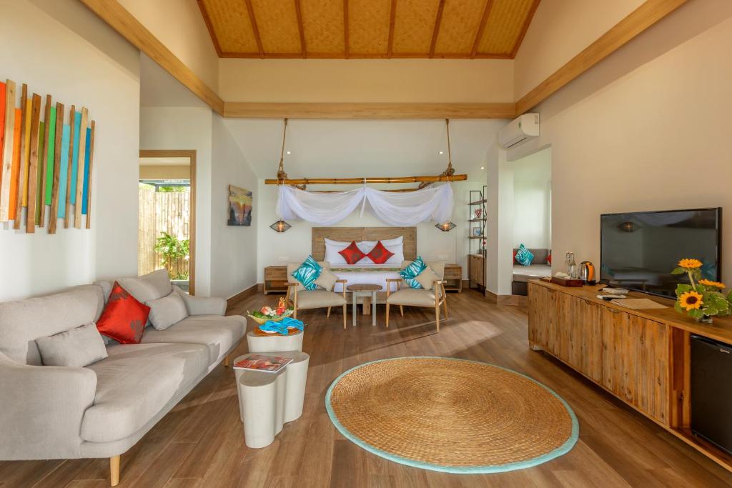 a living room with a couch and a tv at Pax Ana Doc Let Resort & Spa in Ninh Hòa