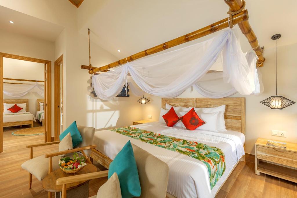 a bedroom with a bed and a room with a mirror at Pax Ana Doc Let Resort & Spa in Ninh Hòa