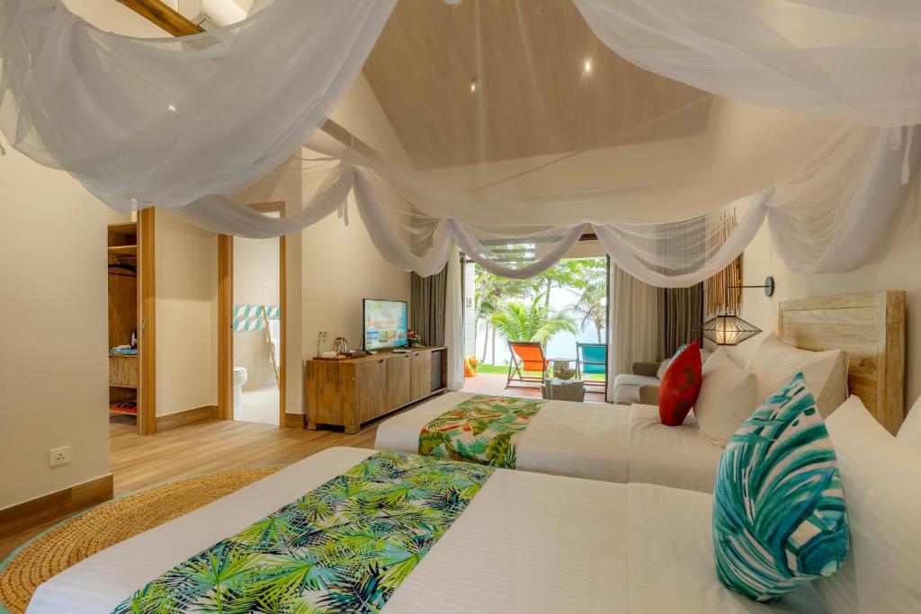 a bedroom with two beds and a living room at Pax Ana Doc Let Resort & Spa in Ninh Hòa