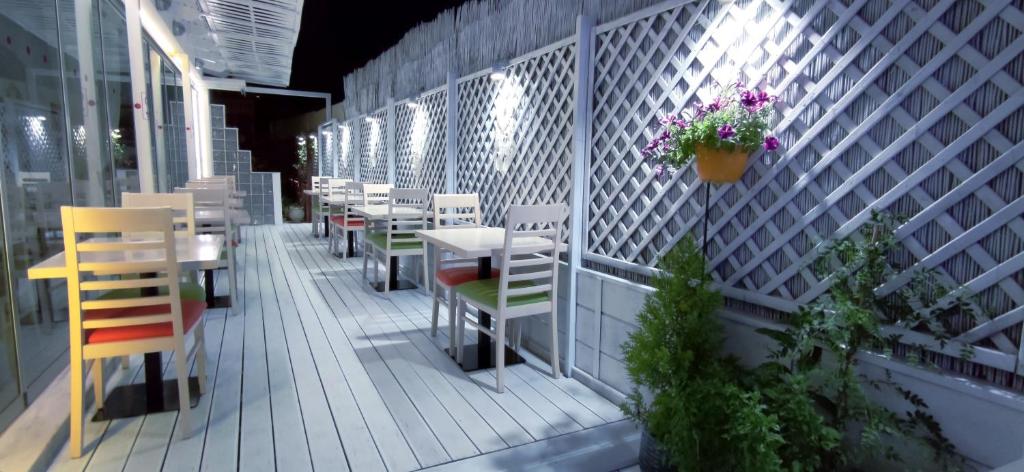a patio with tables and chairs and a flower pot at Thalia deco City & Beach Hotel in Hersonissos