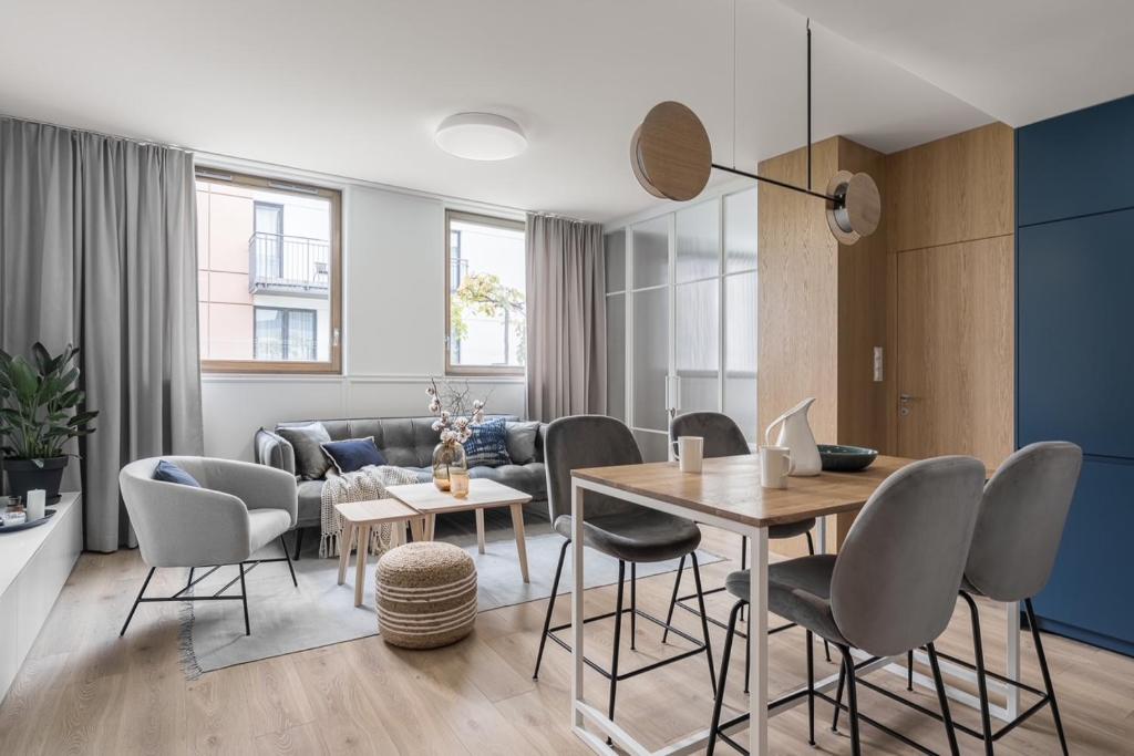 a living room with a table and chairs and a couch at Blue16 by OneApartments in Gdańsk