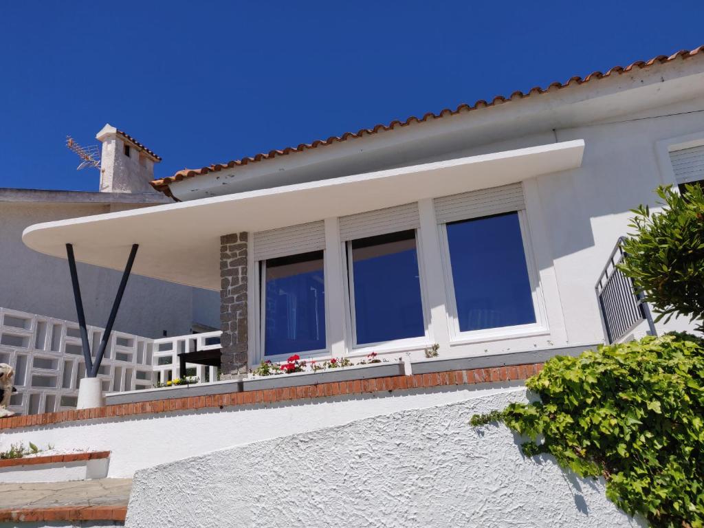 a house with windows on the side of it at Casa Belo Horizonte in Praia da Barra