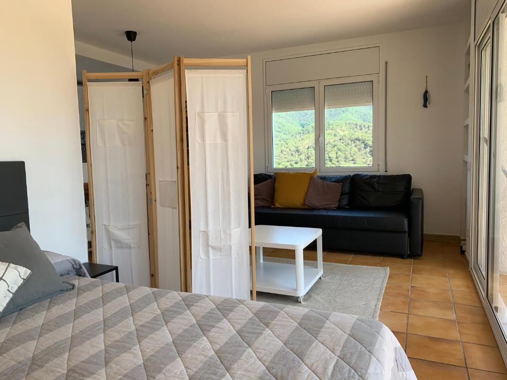 Habitación con cama, sofá y ventana en Apartamento muy tranquilo con piscina, en Tossa de Mar