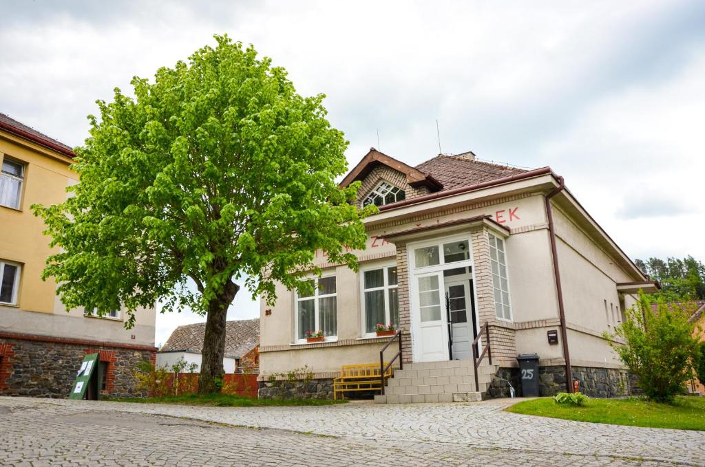 una casa con un árbol delante de ella en Apartmán Kampelička, en Rataje nad Sázavou