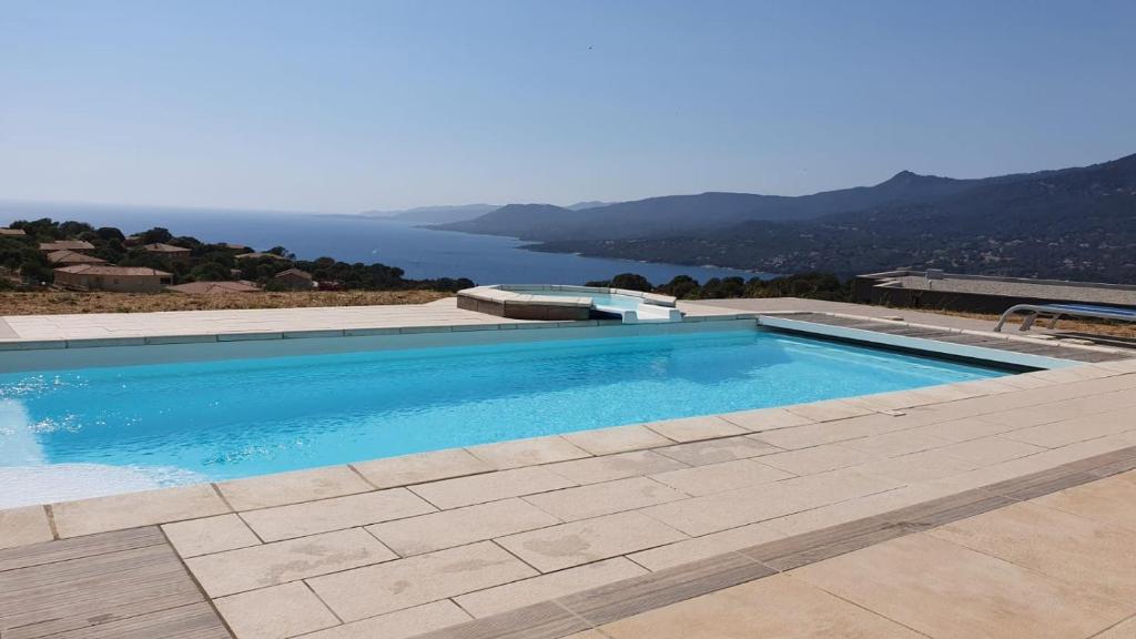 une piscine avec vue sur l'eau dans l'établissement Maison vue mer Propriano Viggianello, à Viggianello