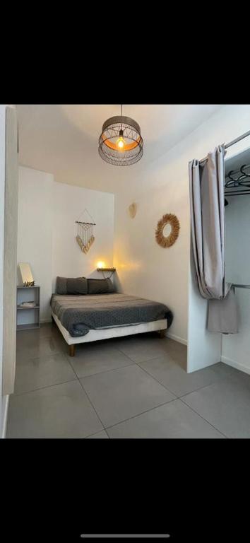 une chambre avec un lit et un lustre dans l'établissement New! Charmant T2 idéalement situé au coeur du centre historique., à Aix-en-Provence