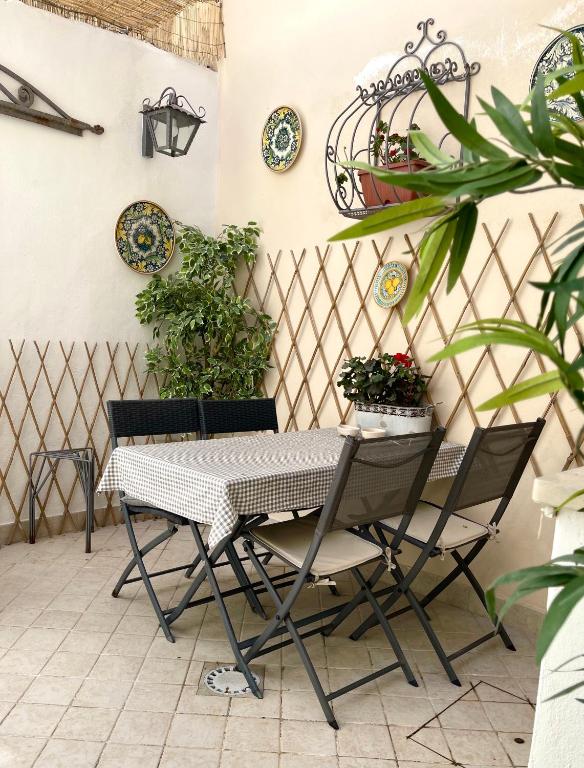stół i krzesła na patio z roślinami w obiekcie Ortigia MaaM Apartment w Syrakuzach