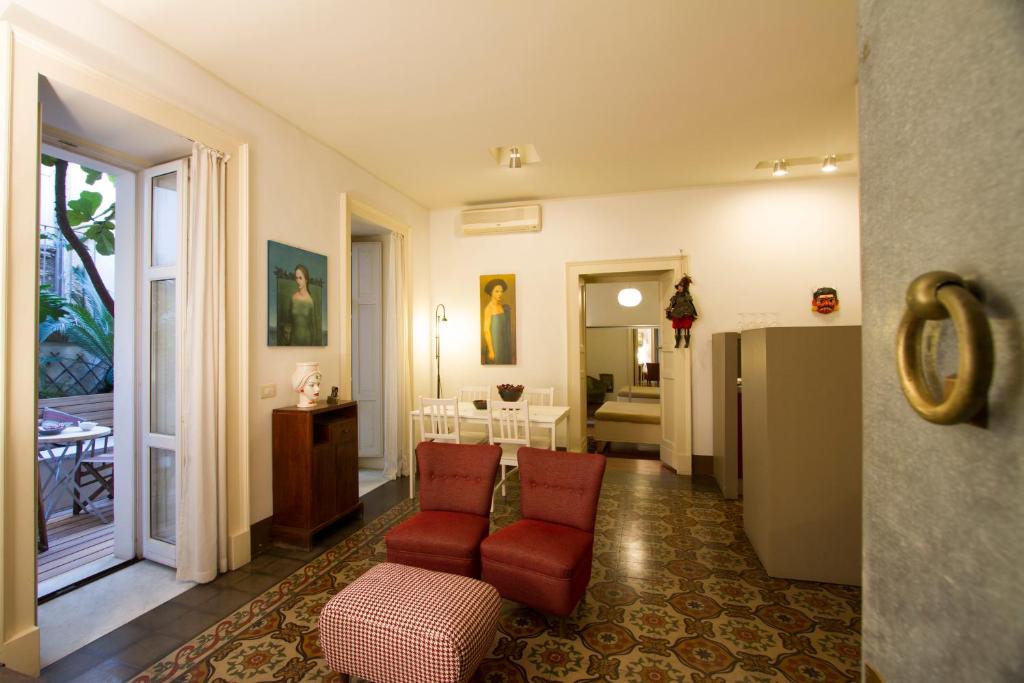 カターニアにあるTre Vie apARTment con terrazzo giardino pensileのリビングルーム(赤い椅子2脚付)、キッチン