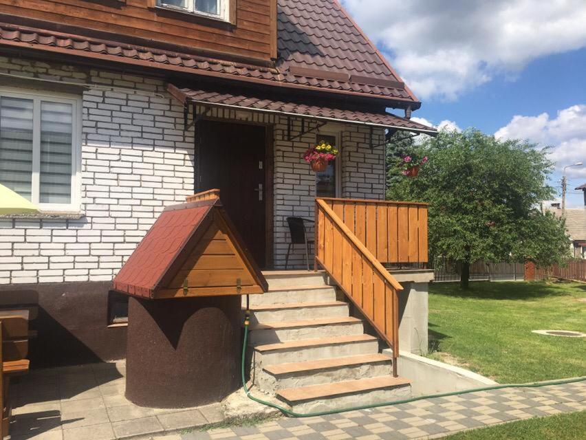 una casa con una casa de perros en las escaleras en Apartament Pod Wiśnią, en Supraśl
