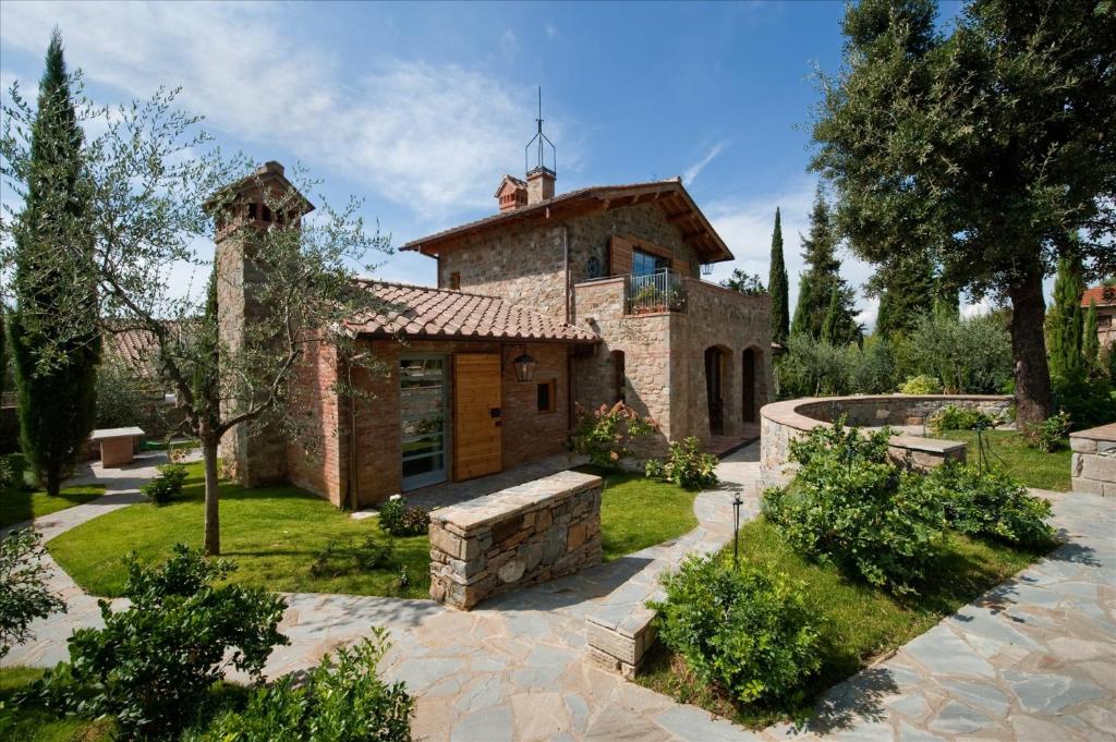 uma grande casa de pedra com um jardim em frente em Fattoria Casamora - Villa La Leccina em Pian di Scò