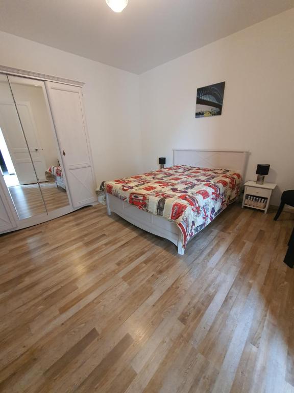 une chambre avec un lit et un parquet dans l'établissement Sojeaflor, à Coutras