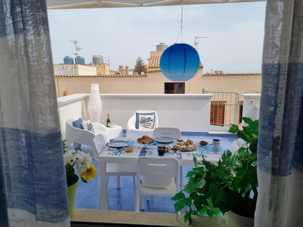 a patio with a table and chairs on a balcony at Le petite Maison in San Vito lo Capo